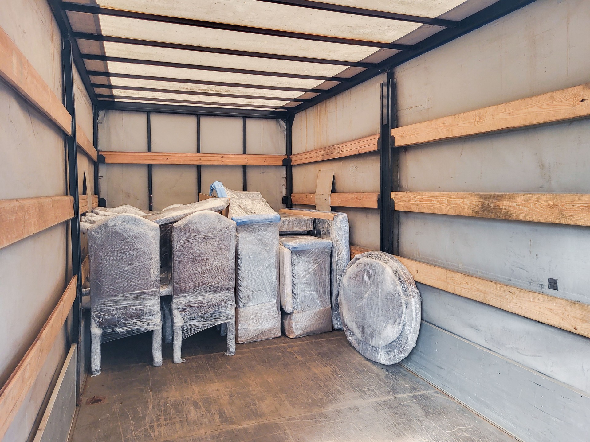 Moving truck interior with furniture and boxes prepared for transport